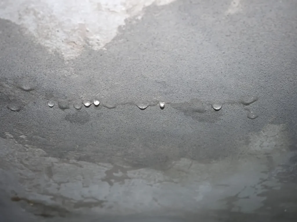 Moisture and water droplets spreading across a ceiling from a clogged AC condensate line in Continental Ranch, AZ