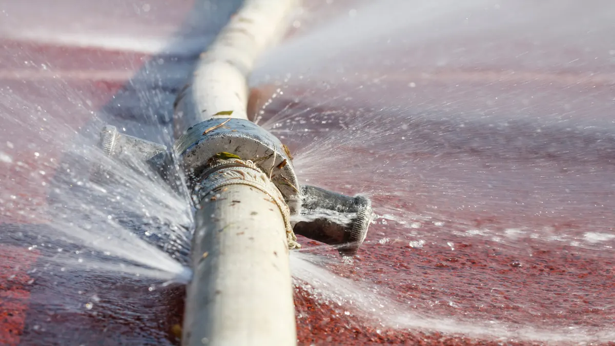 Water spraying from a leaking supply line, like a failed rooftop swamp cooler water feed