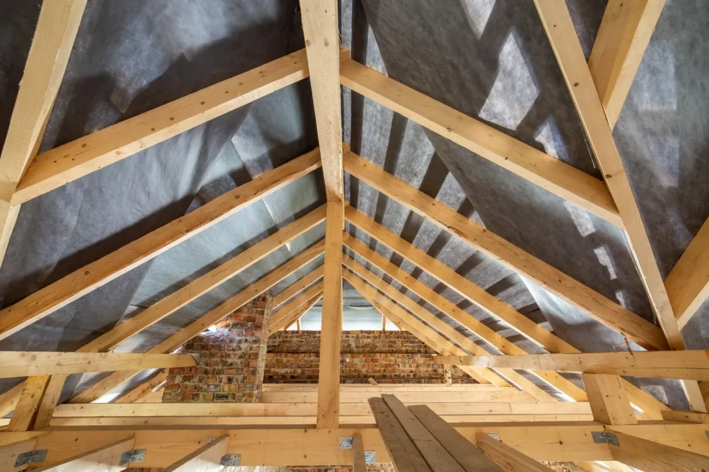 Attic interior with exposed wooden roof beams, the framing and sheathing surfaces attic mold removal in Tucson homes has to inspect and treat