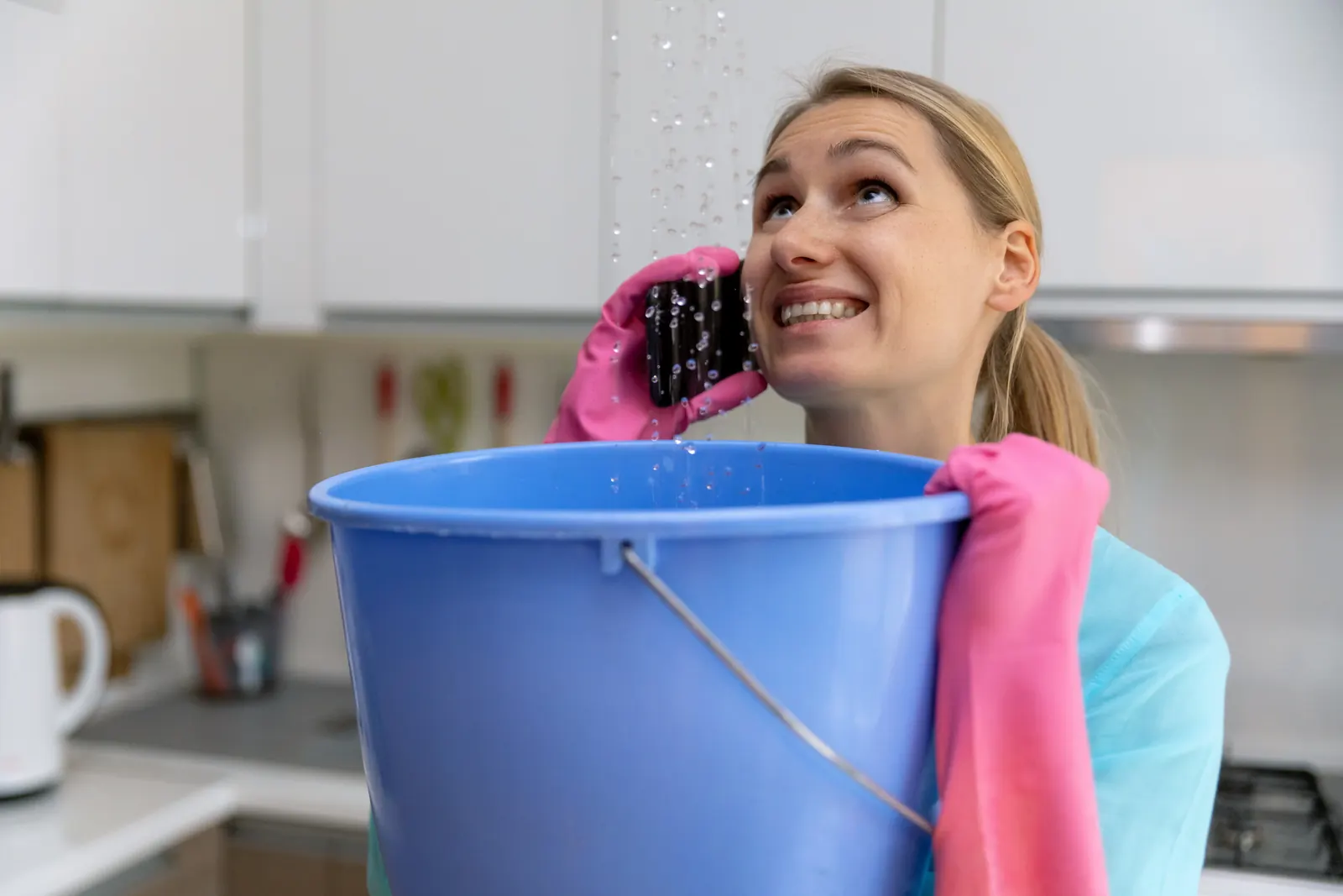 Homeowner catching ceiling drips in a bucket during a swamp cooler leak in Casas Adobes, AZ