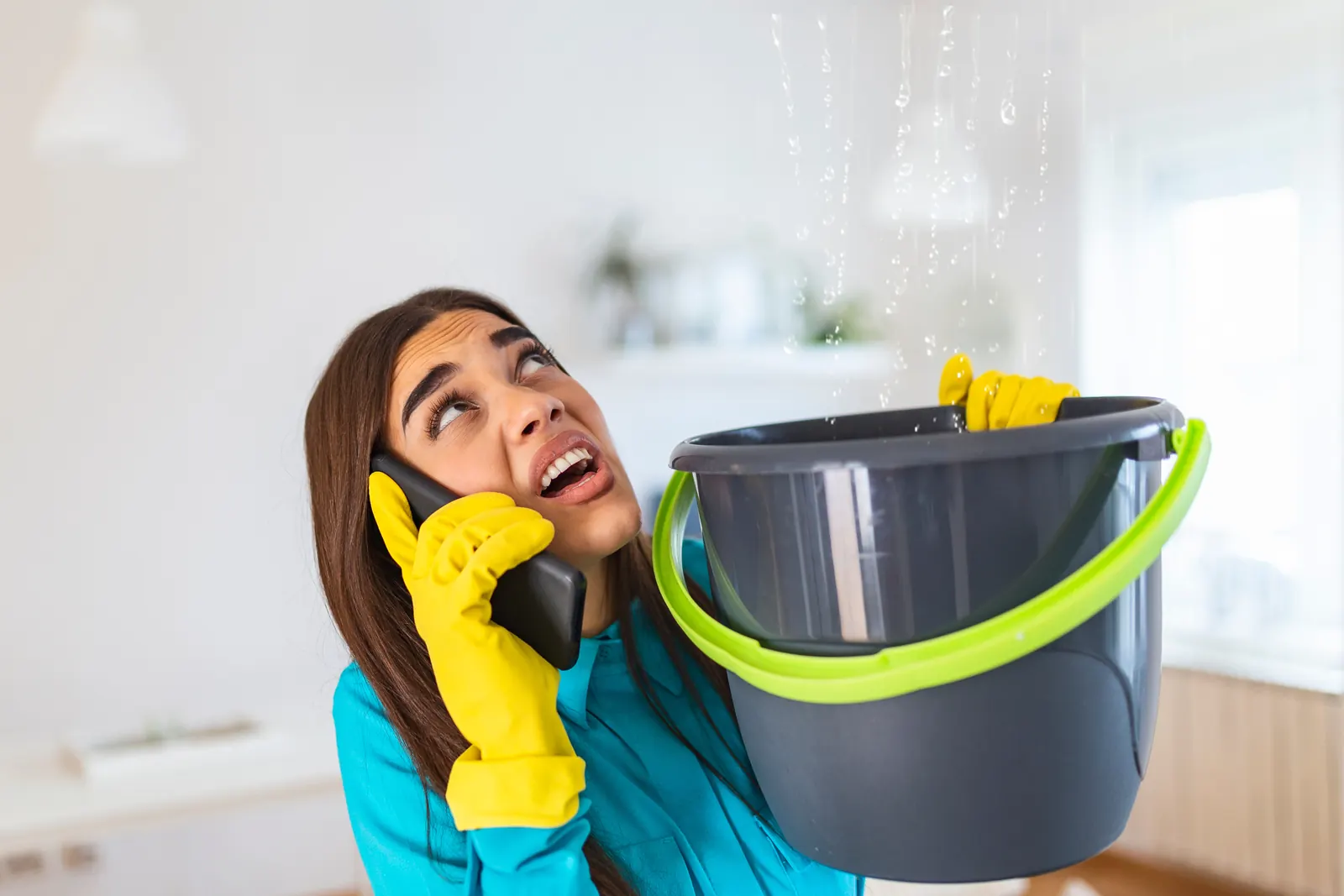 Homeowner calling for water damage help as a swamp cooler leak drips from the ceiling in Oro Valley, AZ
