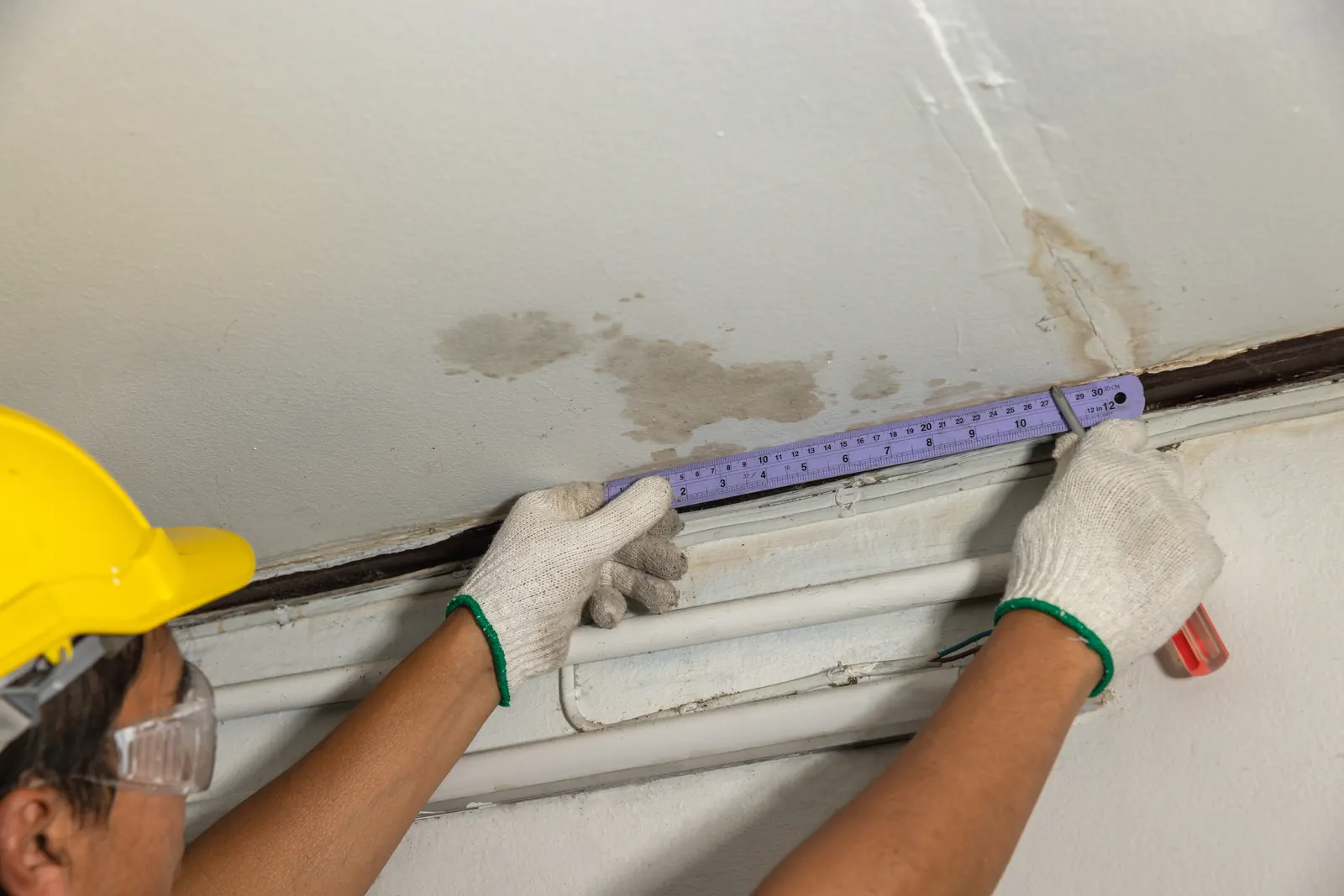Technician opening a water-stained ceiling to trace a swamp cooler leak in a Tanque Verde, AZ home