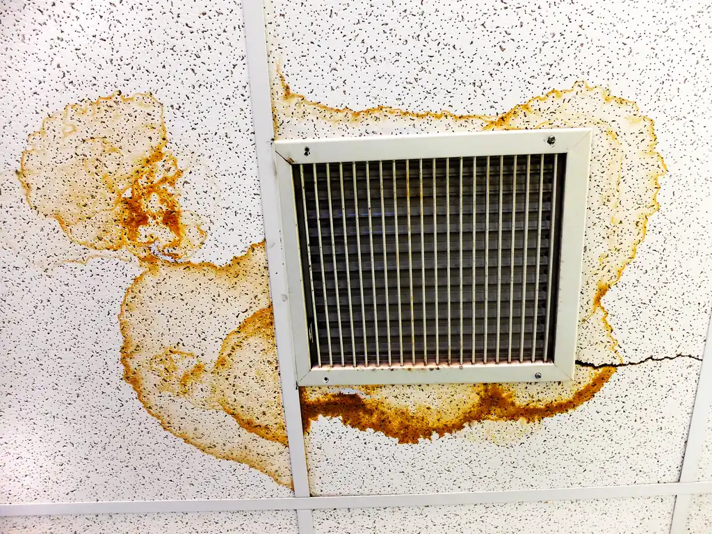 Water-damage stains around a ceiling vent from a swamp cooler duct leak at a Vail, AZ property